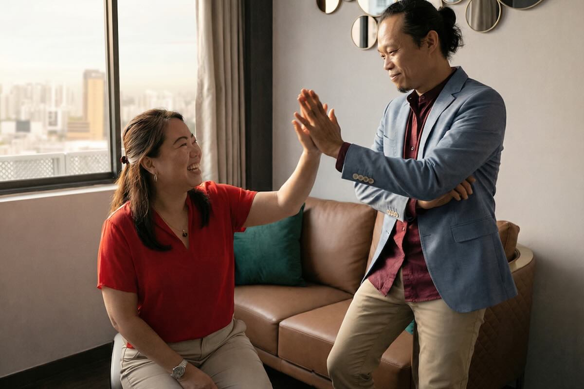 Executive communication coaching session with coach Ellery Ng and client celebrating success with a high five in a private coaching room