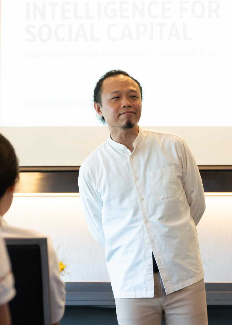 Executive communication coach Ellery Ng standing beside a presentation slide while facilitating a communication and confidence session