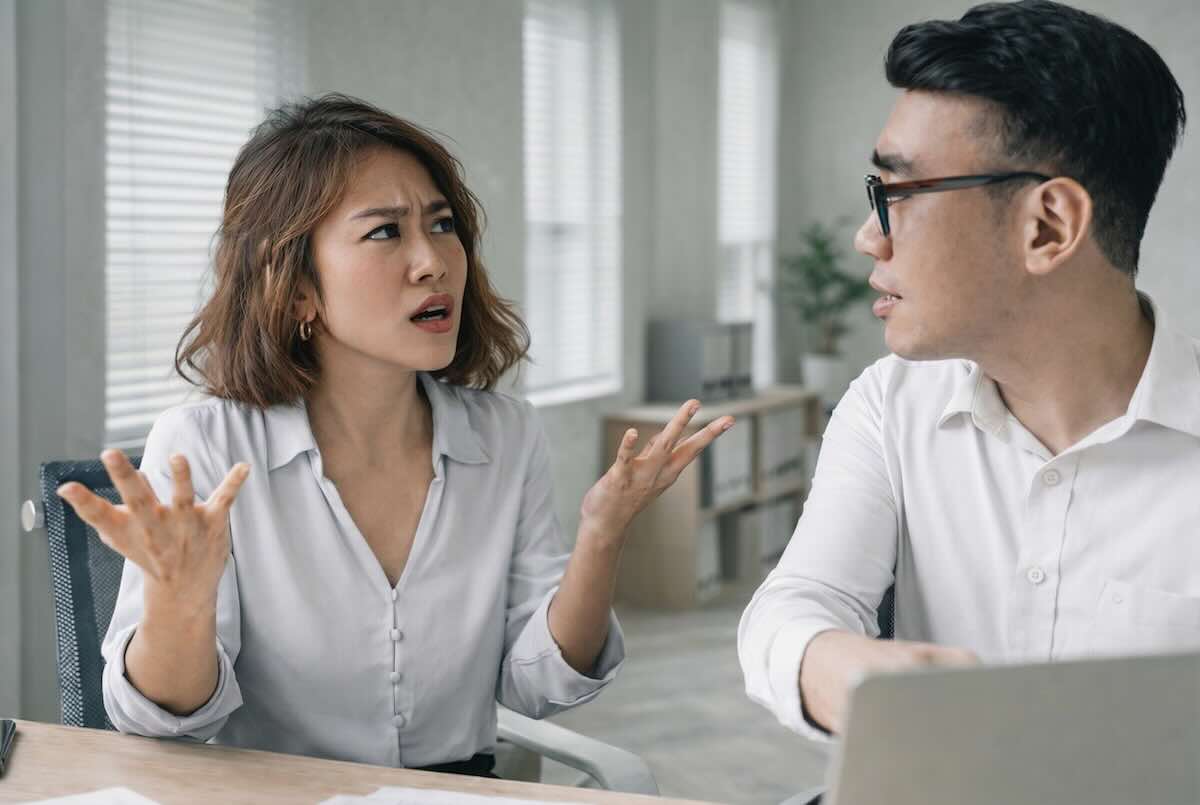 Woman executive gesturing in frustration while speaking to her colleague because both have their fair share of interpersonal communication difficulties