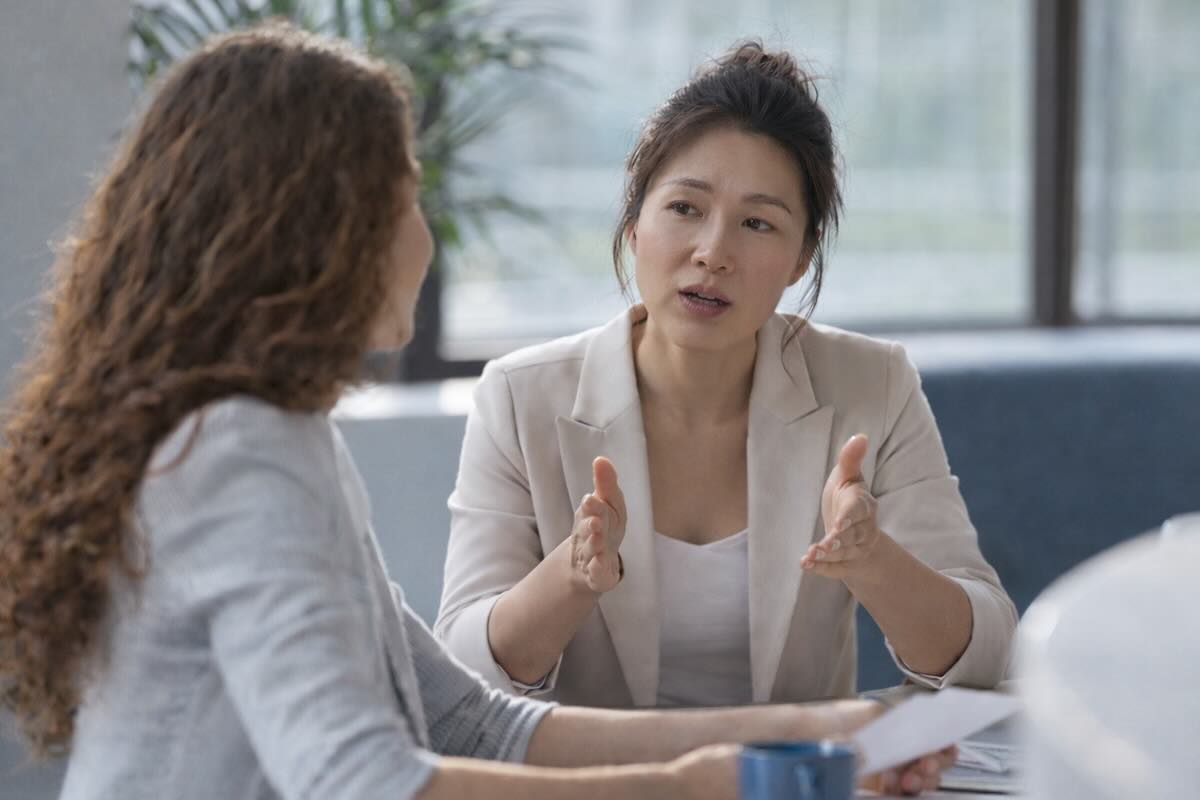 female leader applying executive coaching skills in Singapore to navigate emotional workplace conversation with team member