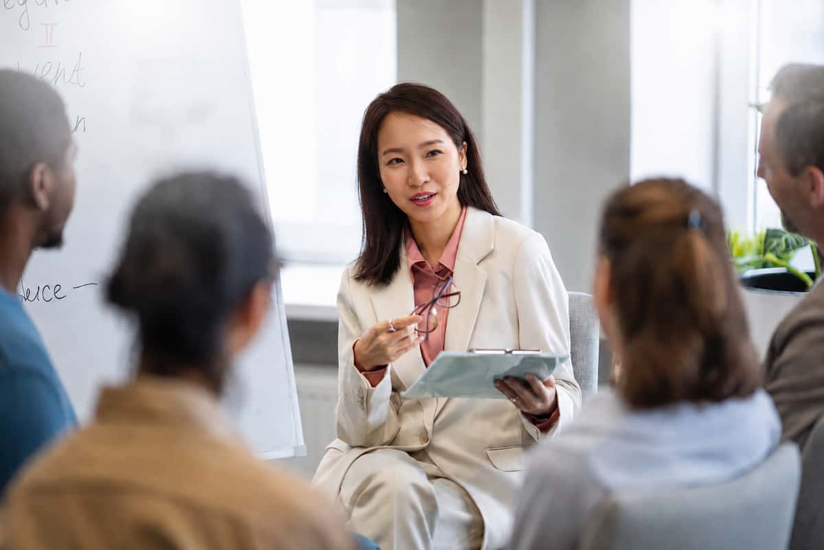 Woman demonstrating confident public speaking skills in a group discussion